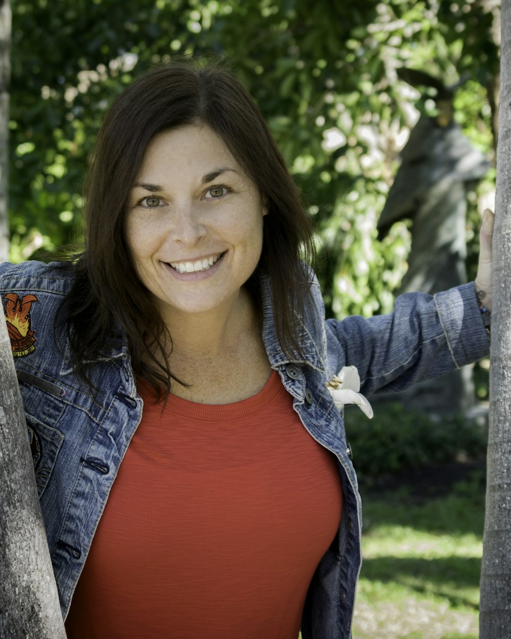 smiling woman in blue denim jacket and red shirt