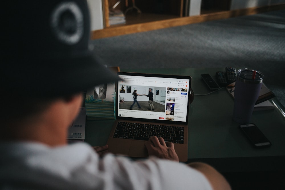 person in white long sleeve shirt using macbook pro