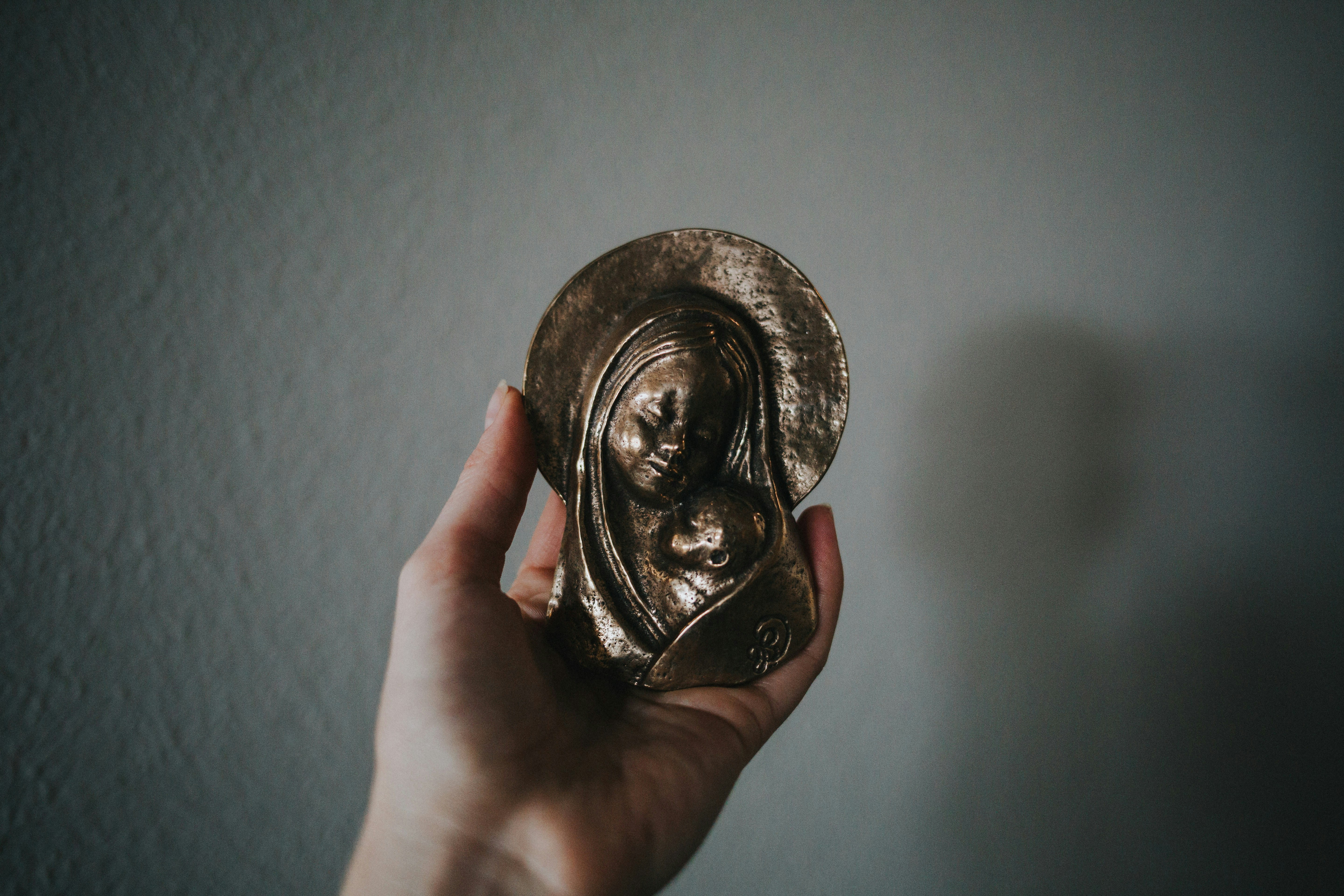 person holding gold round coin