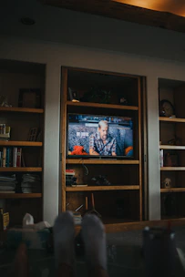 Handyman installing shelves on a living room wall in a cozy Edinburgh home.