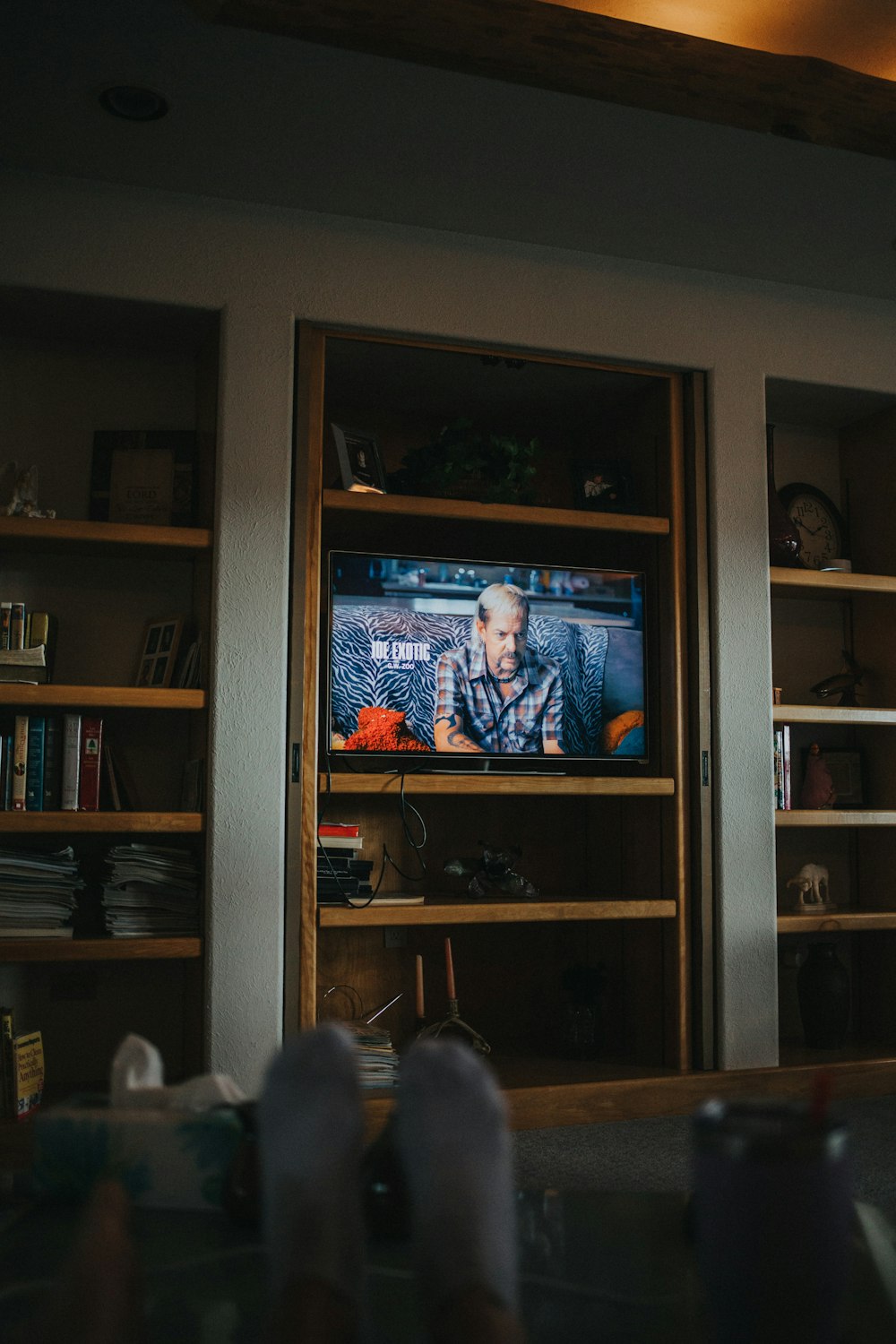 Schwarzer Flachbildfernseher eingeschaltet mit Mann in blauer Anzugjacke