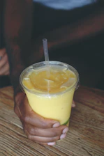 Close-up of a vibrant protein shake with fresh ingredients on a wooden table.