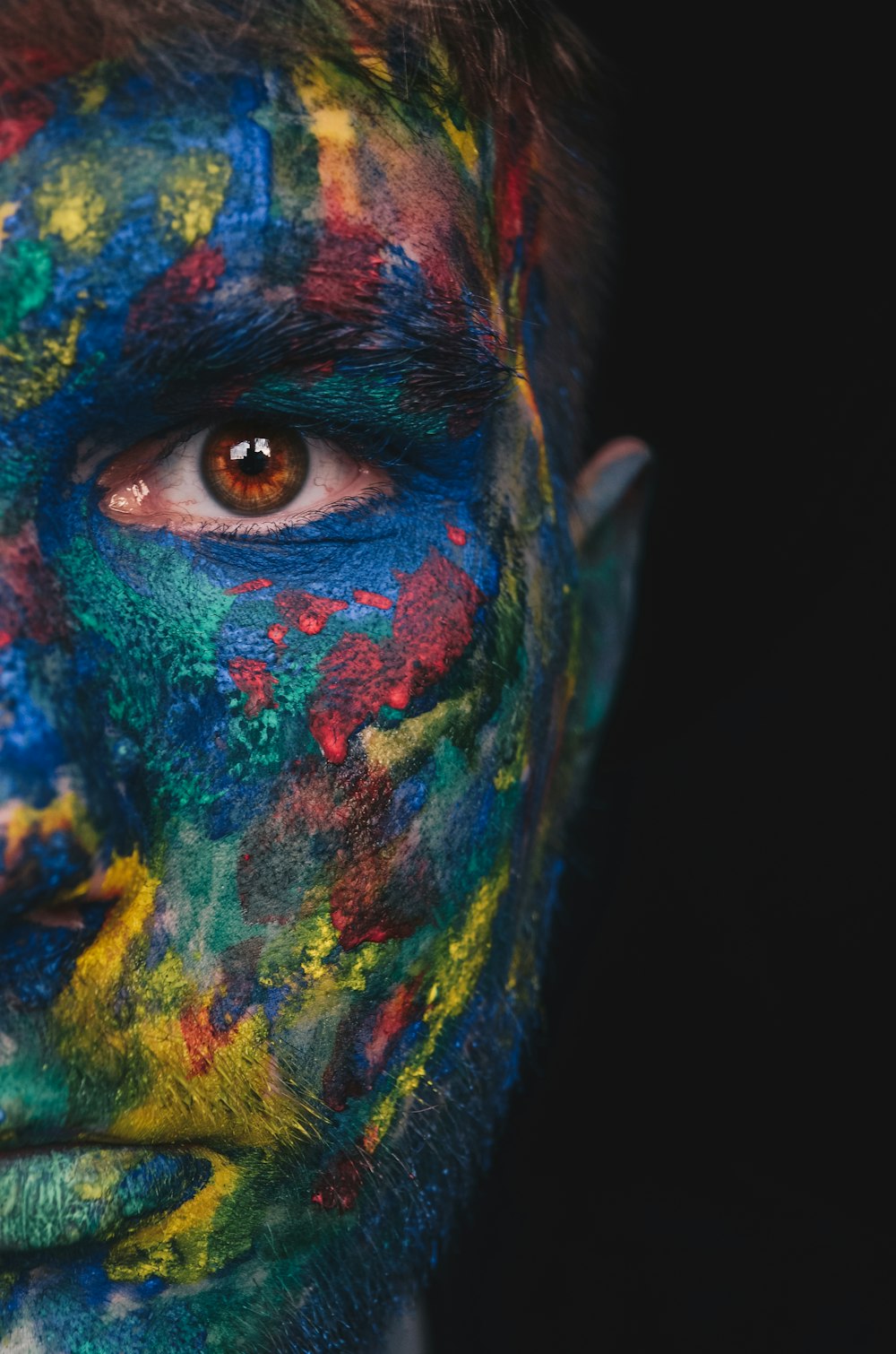 person with green blue and yellow face paint