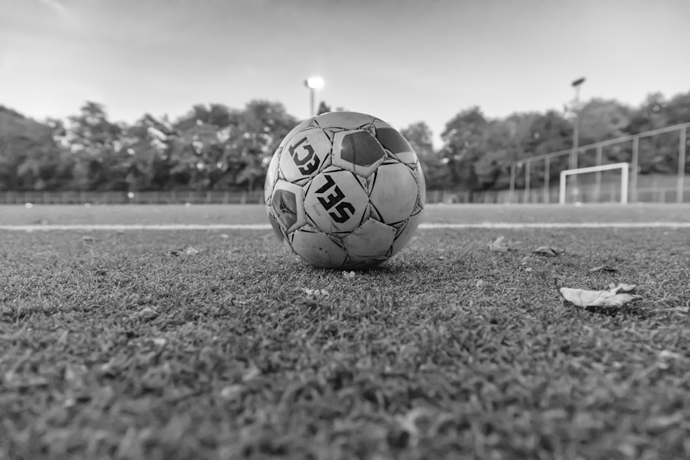 soccer ball on grass field in grayscale photography