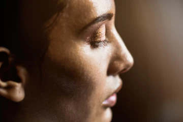 Perfil de rostro femenino con luz cálida que resalta el pómulo y la mandíbula
