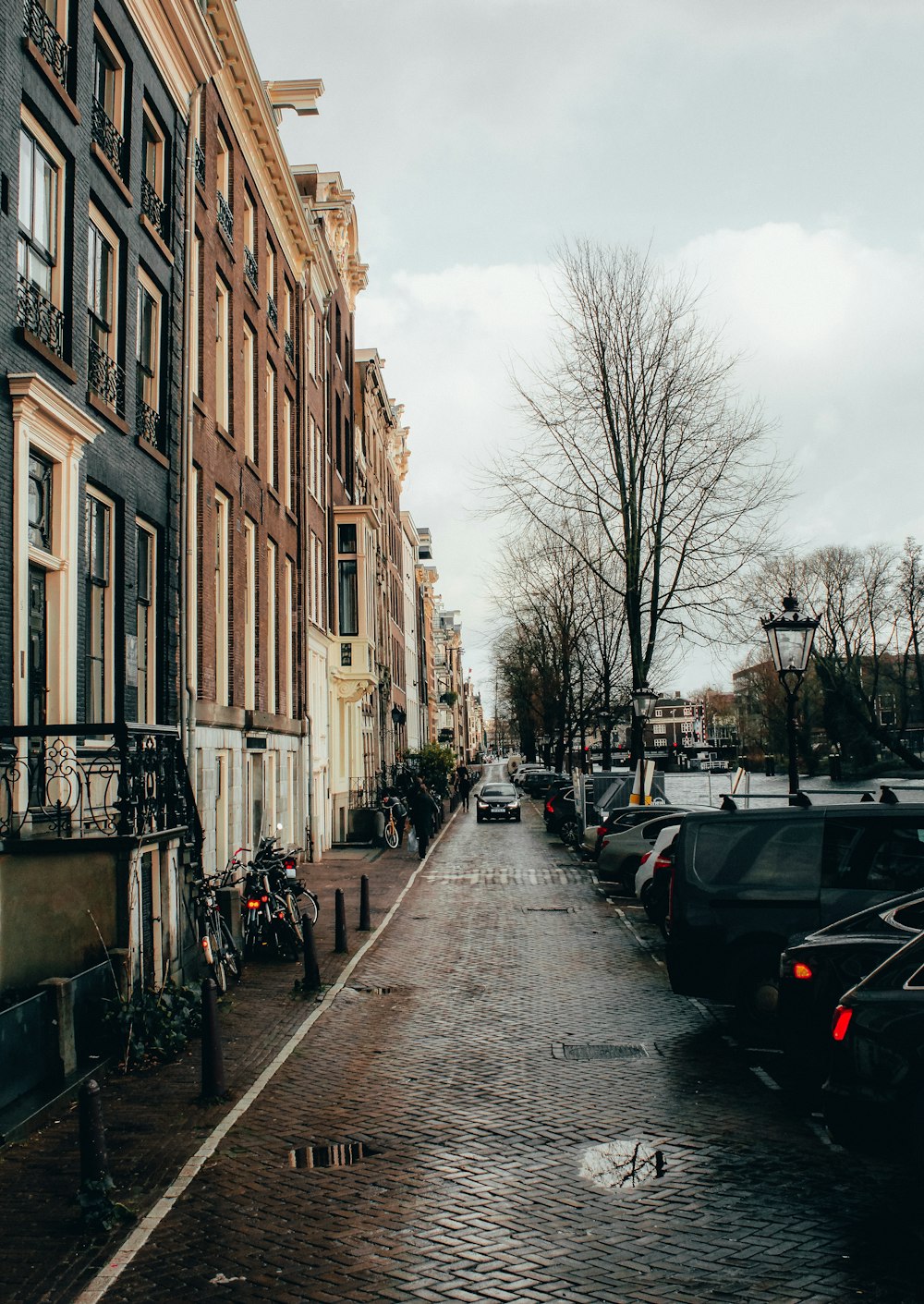 cars parked on side of the road in between buildings