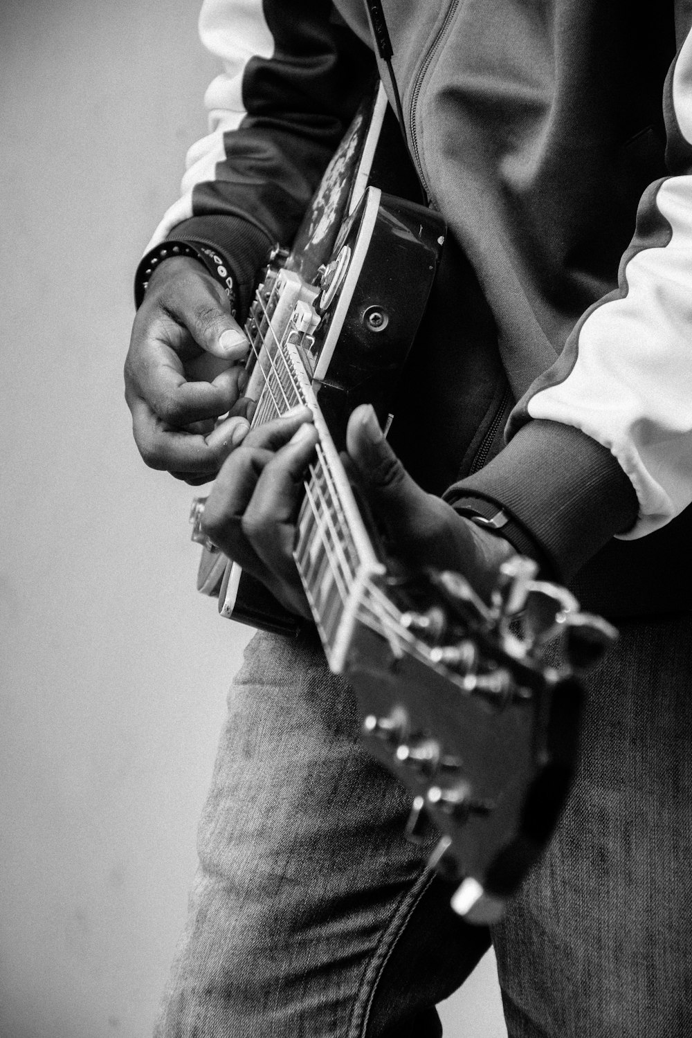 person playing guitar in grayscale photography
