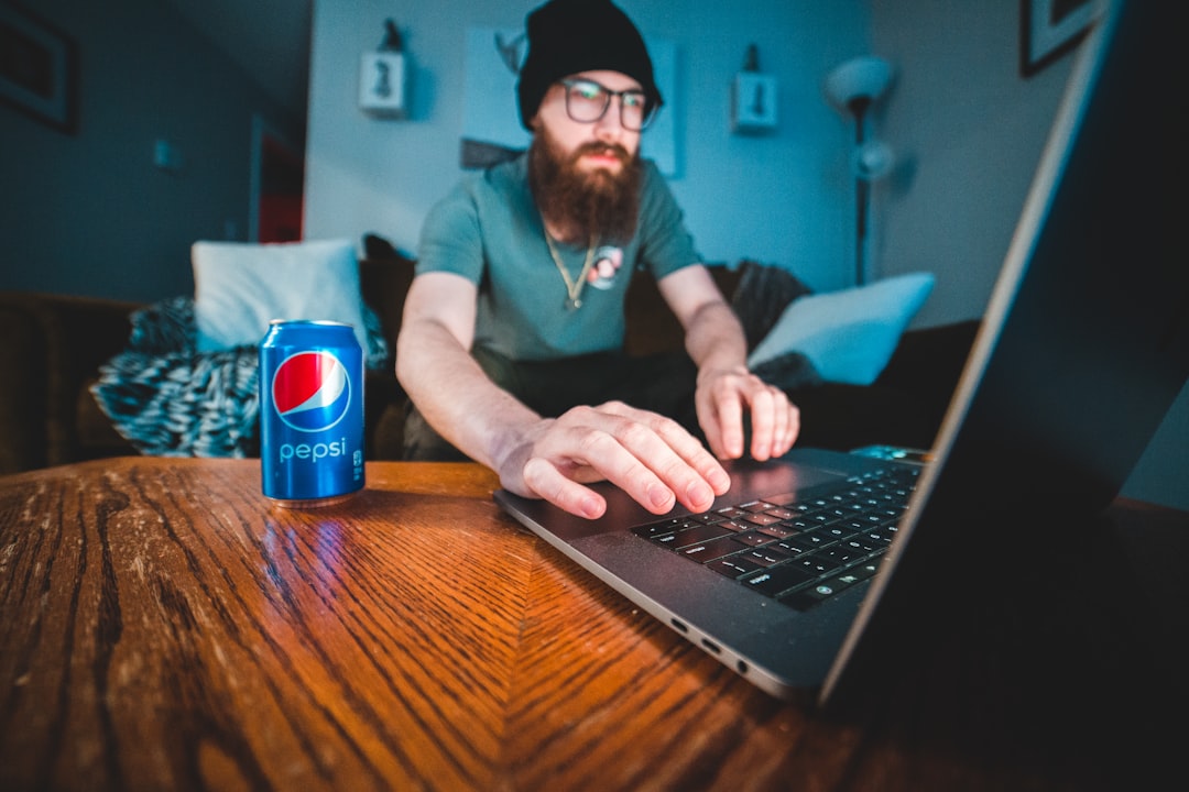 man in blue polo shirt using black laptop computer