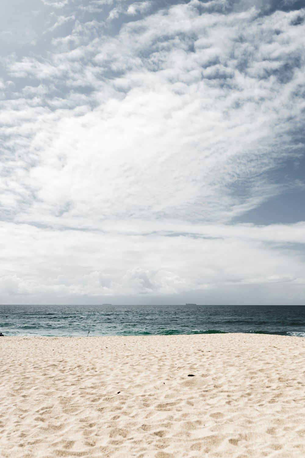white sand beach under white clouds and blue sky during daytime