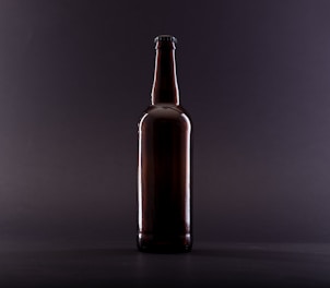 brown glass bottle on black surface