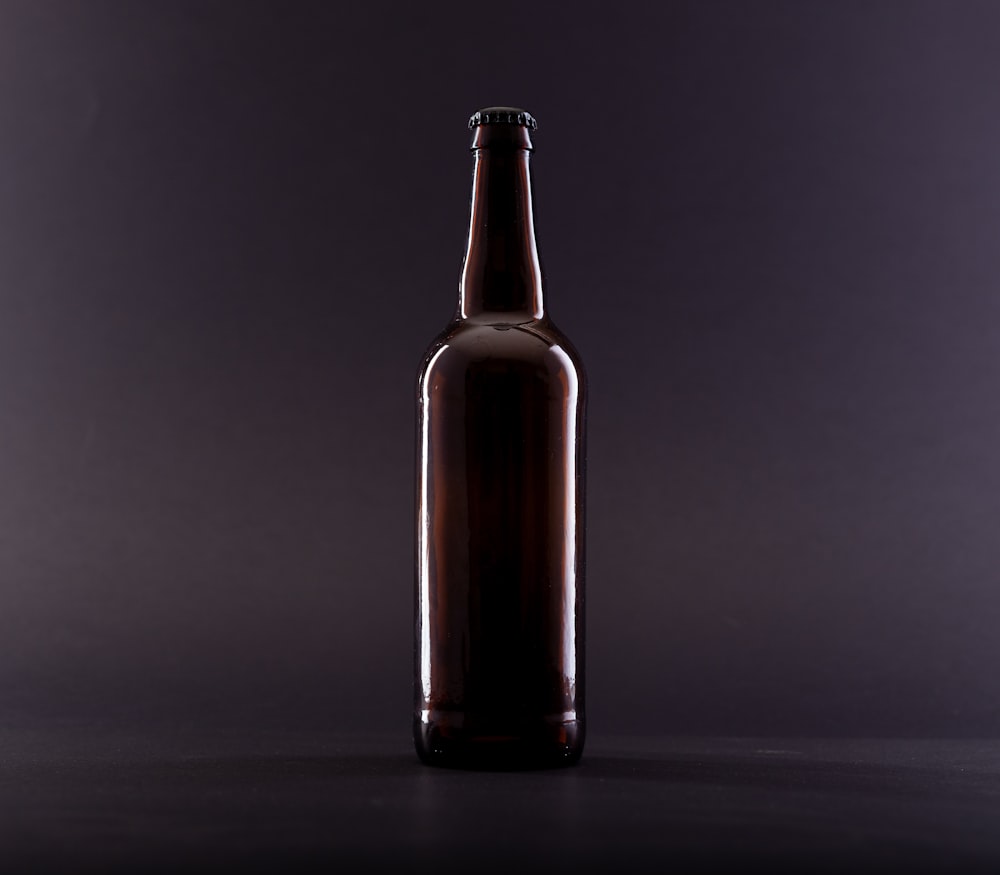 brown glass bottle on black surface