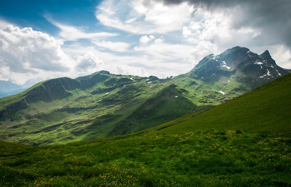 green mountains under white clouds and blue sky during daytime