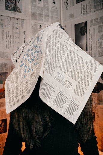 Newspaper on womans head news reading absorbing