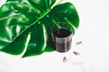 A pristine copper glass sparkling next to herbal leaves symbolizing ayurvedic wellness.