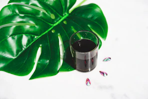 A pristine copper glass sparkling next to herbal leaves symbolizing ayurvedic wellness.