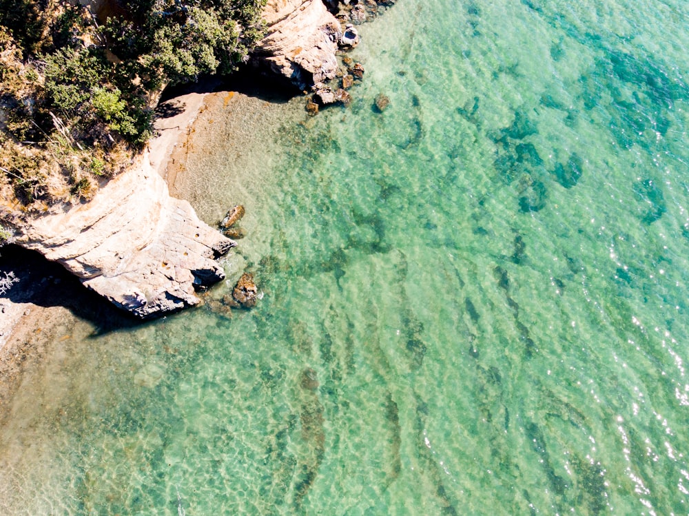 aerial view of white and brown rock formation on body of water during daytime