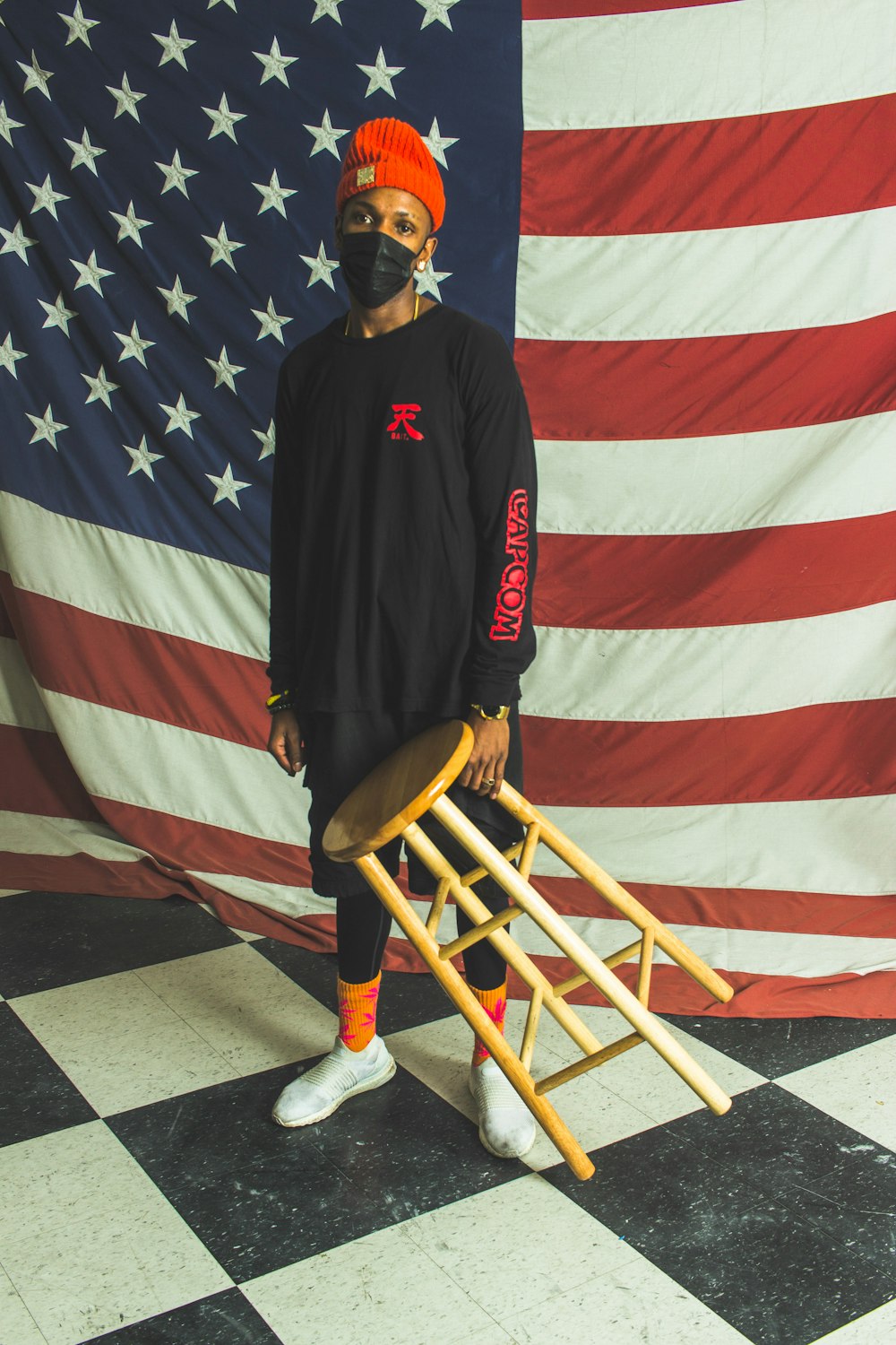 man in black and red nike jacket sitting on brown wooden chair