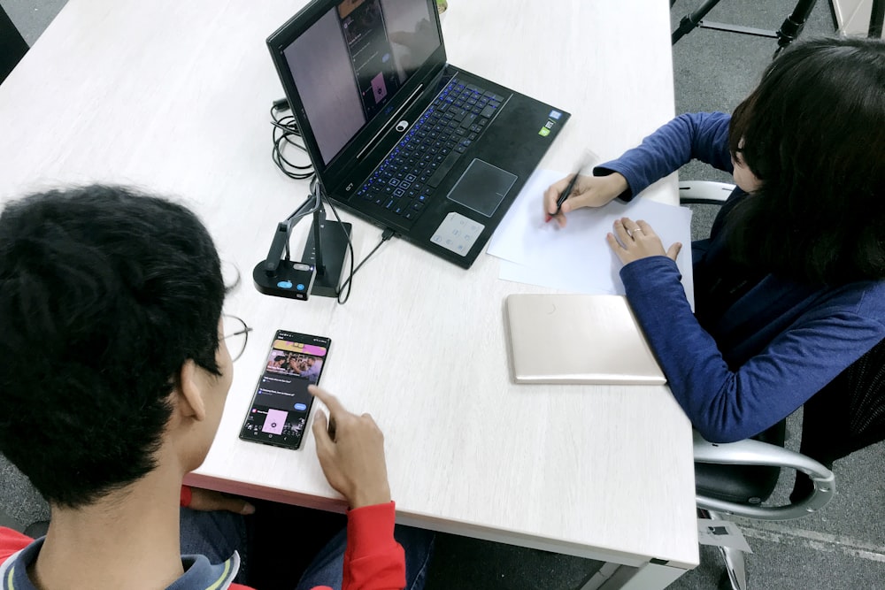 person in blue long sleeve shirt using black laptop computer