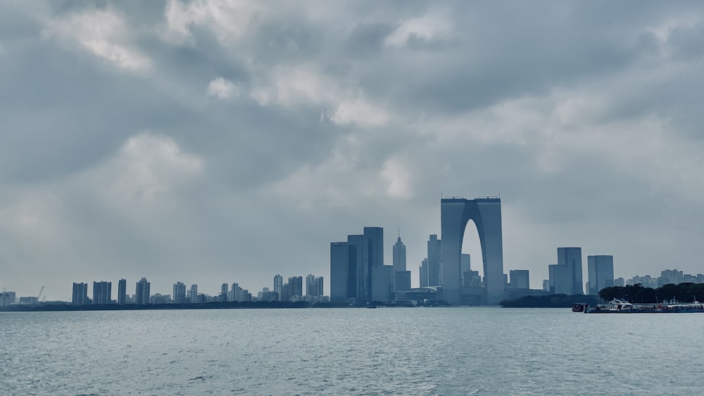 city skyline across body of water under cloudy sky during daytime