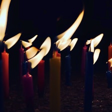 Close-up of colorful handmade candles glowing softly in a warm light.