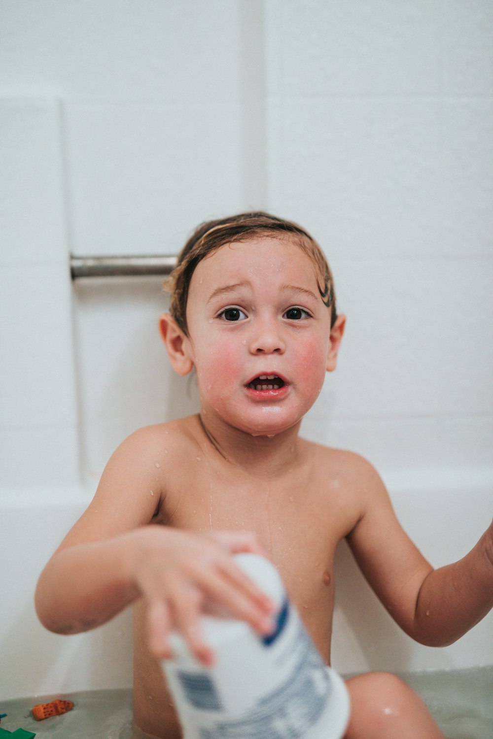 topless boy holding white and blue ball