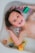 A happy child in a bathtub playing with colorful fizzing bath bombs that release number magnets.