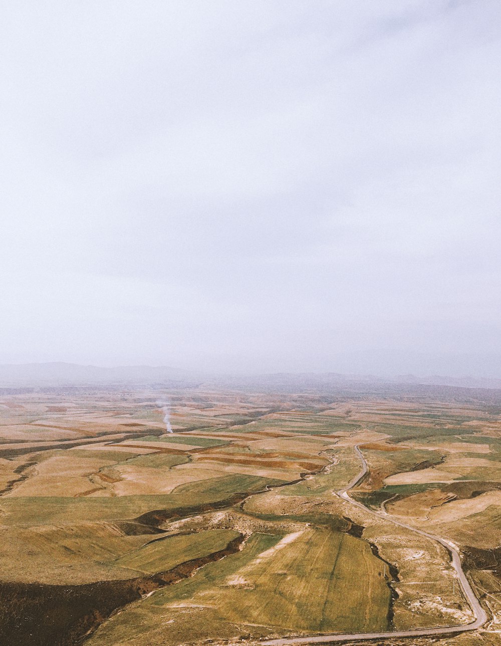 brown and green mountains under white sky during daytime