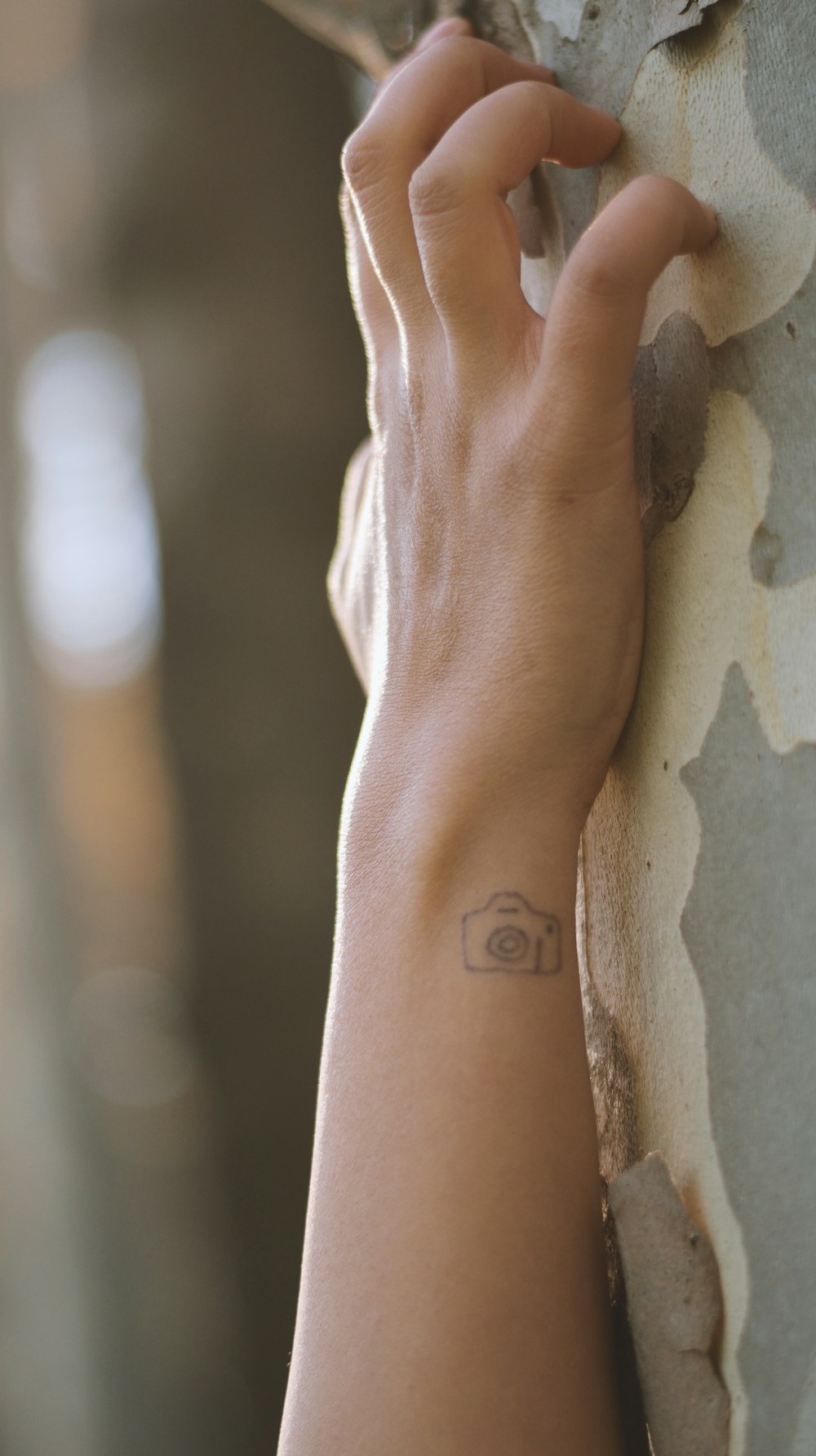 persons left hand with tattoo