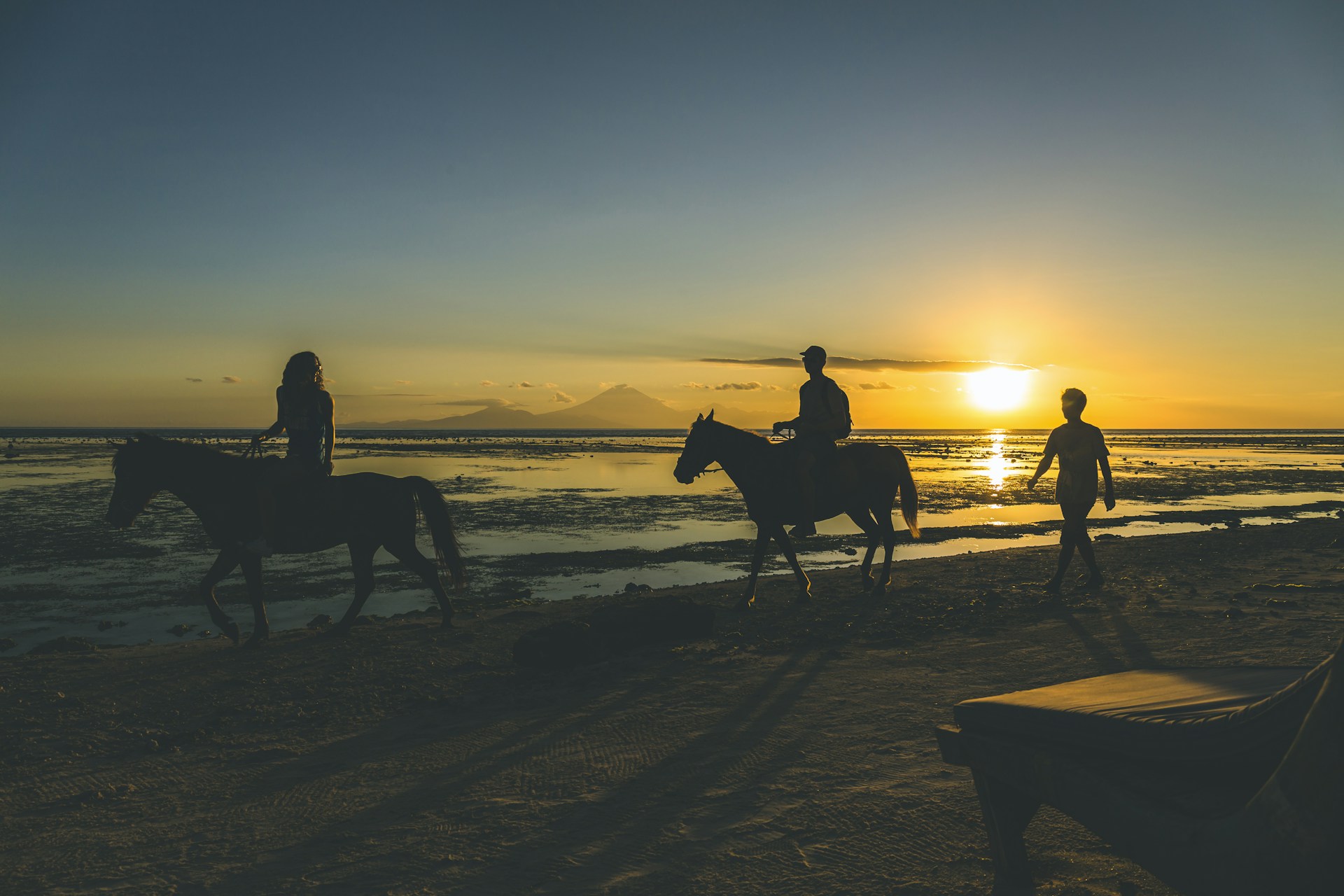 silhouette of 2 people riding horse on beach during sunset