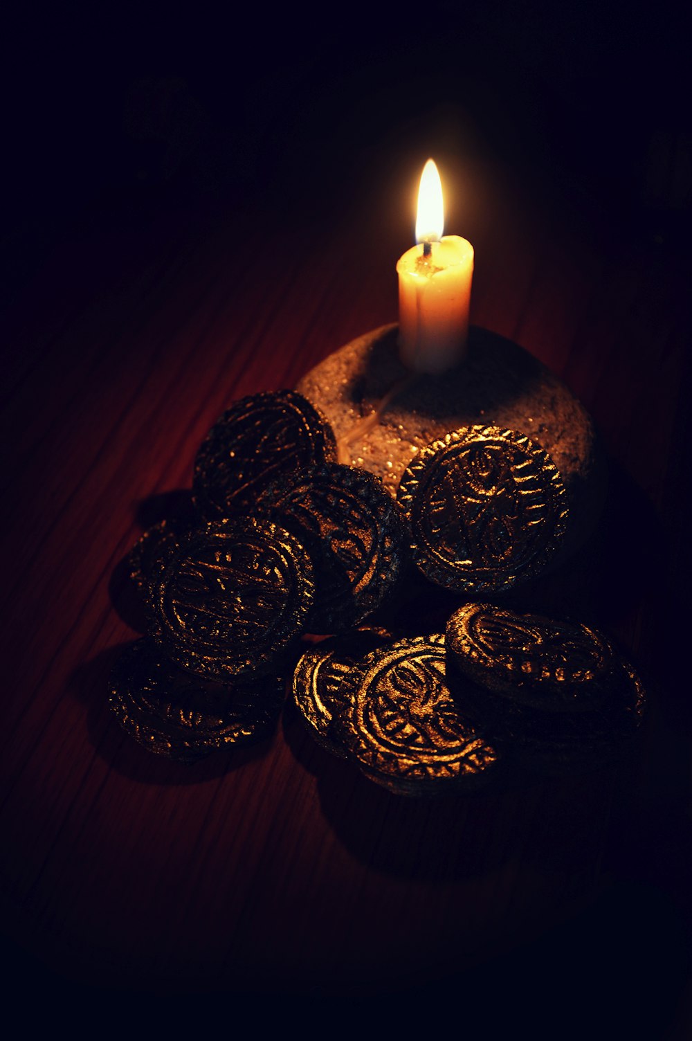 three gold round coins beside white candle