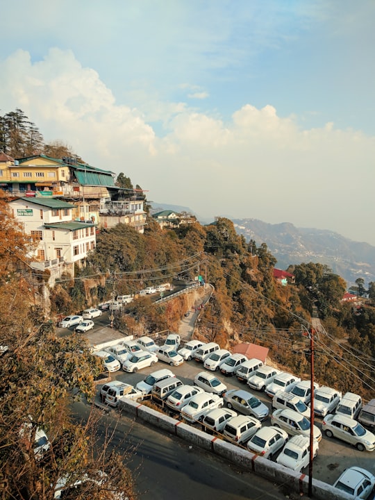 white and brown concrete buildings near green trees during daytime in Mussoorie India
