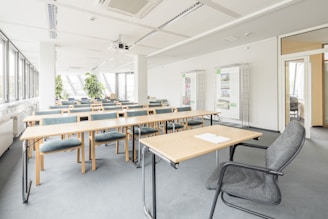 Interior view of a bright, modern classroom with ergonomic furniture and large windows.