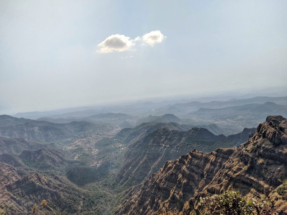 brown and green mountains under white clouds during daytime