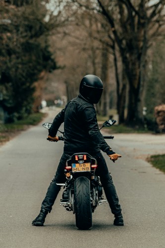 A motorcycle rider from behind on the open road