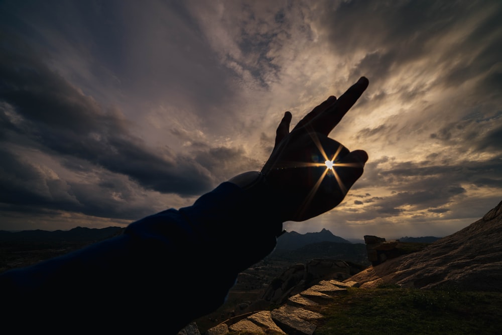 silhouette of person holding windmill during sunset