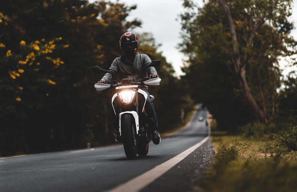 man in black helmet riding motorcycle on road during daytime