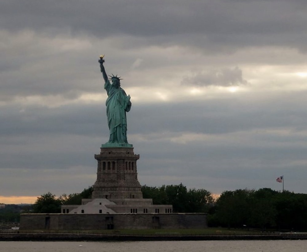 statue of liberty under cloudy sky during daytime