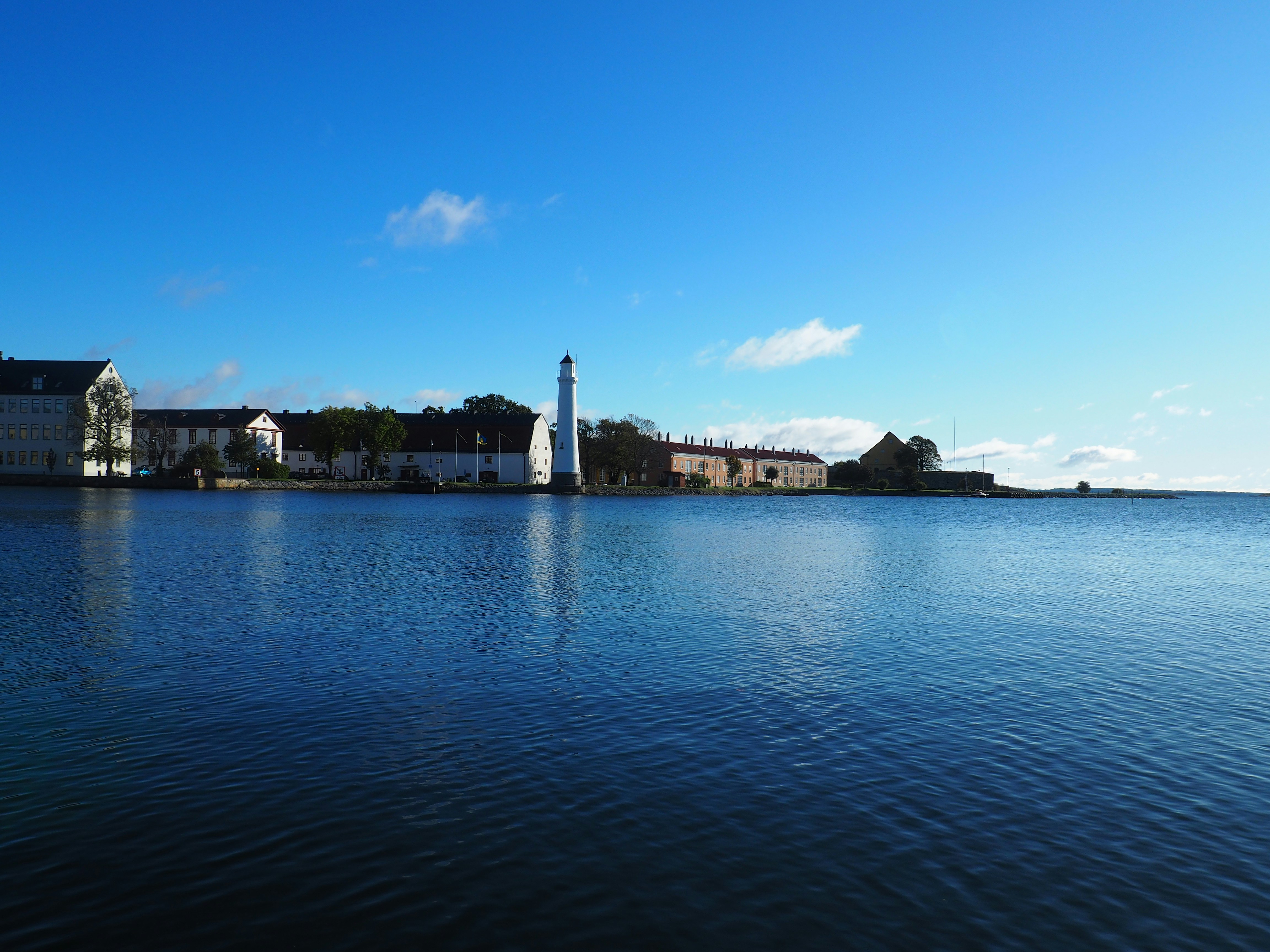 body of water near city buildings under blue sky during daytime
