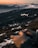 A person flying a drone over a scenic landscape with mountains in the background.