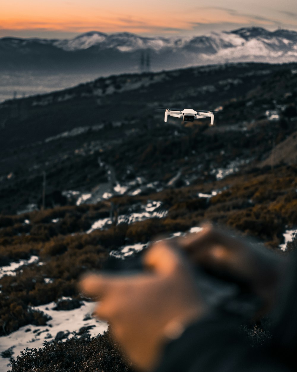 white drone flying over the mountains during daytime