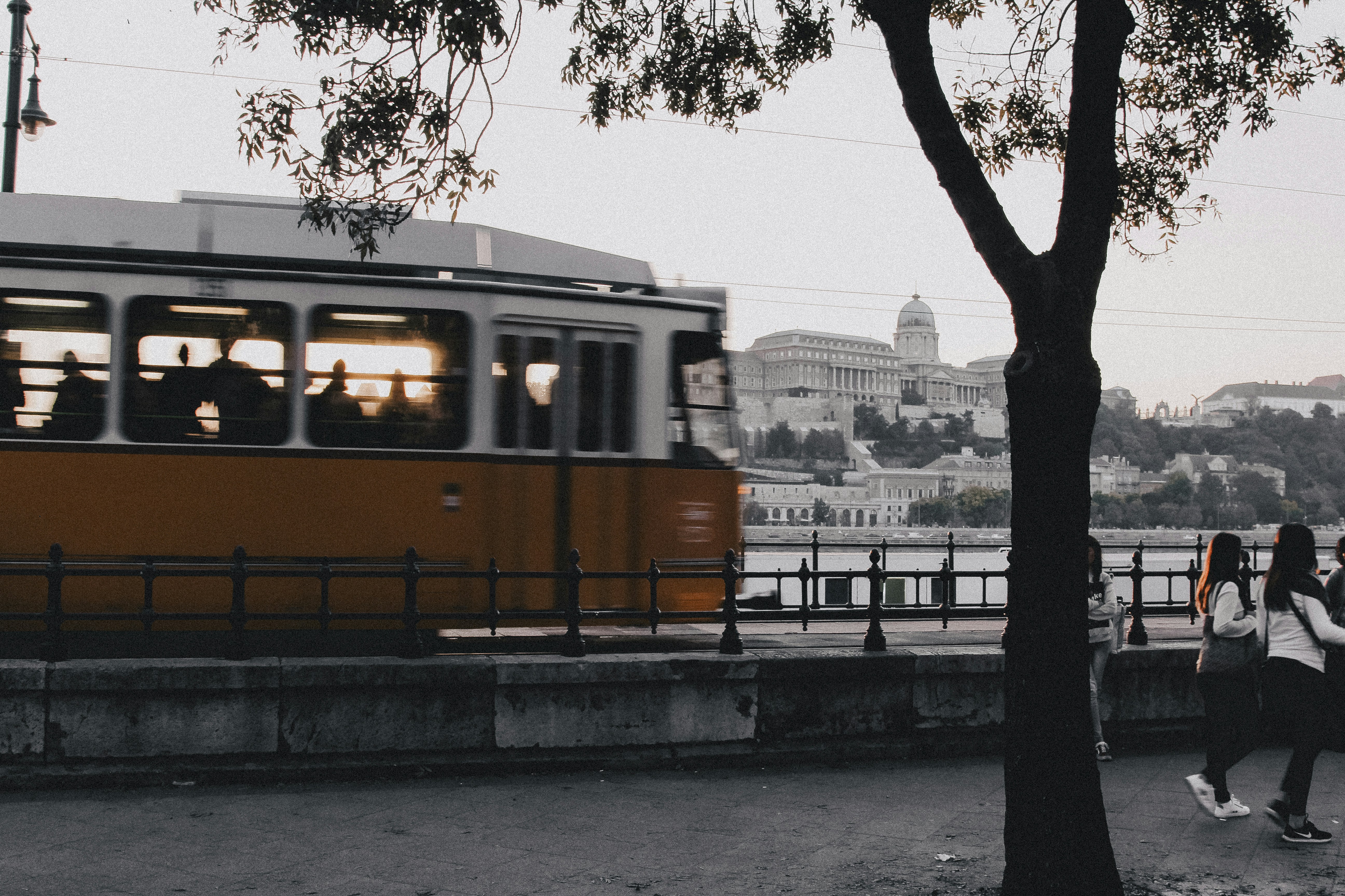 yellow and black train on rail near body of water during daytime, Tram in the Budapest