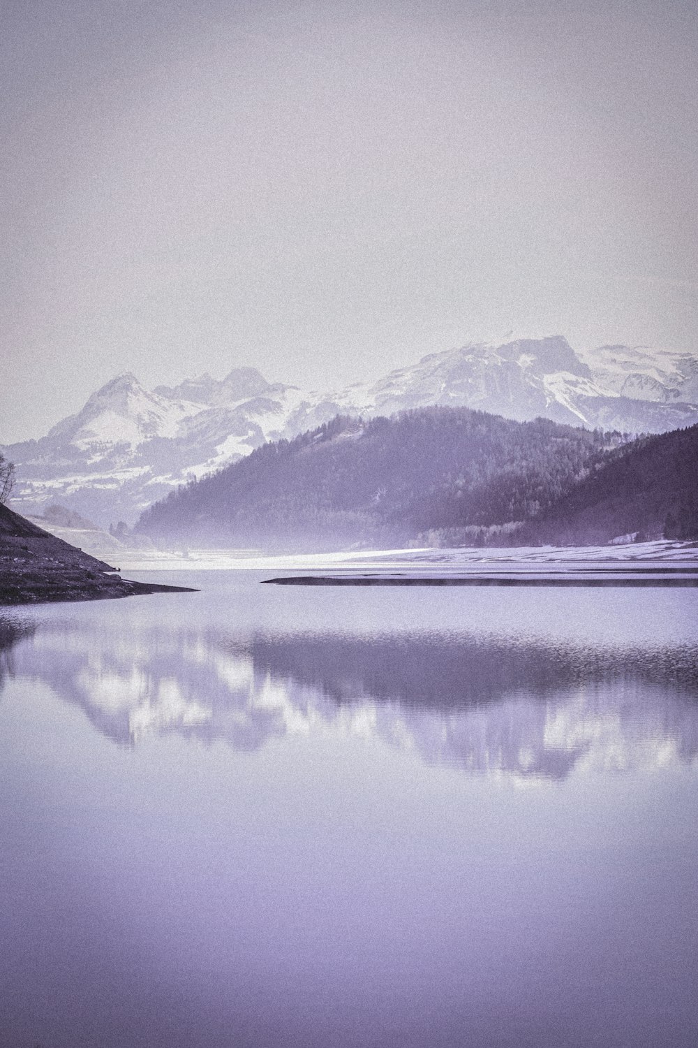 snow covered mountain near lake