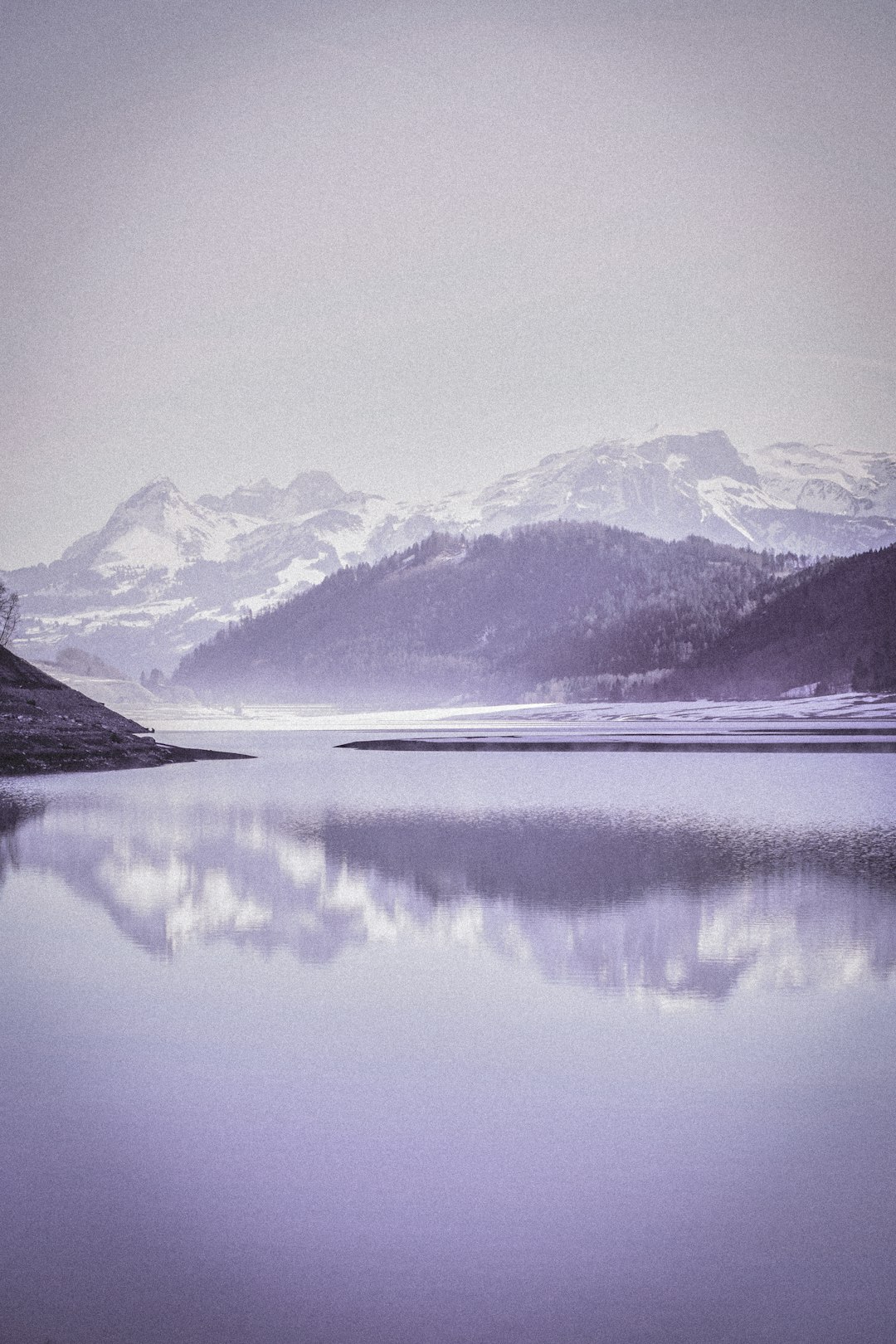 snow covered mountain near lake