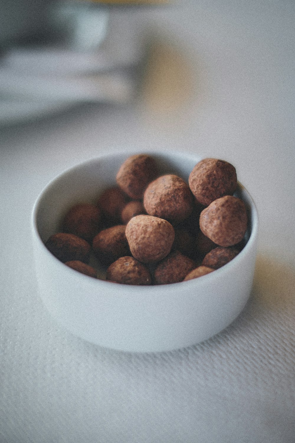 Aliments ronds bruns dans un bol en céramique blanche