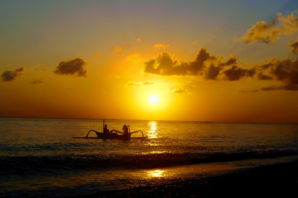 silhouette of 2 people on beach during sunset