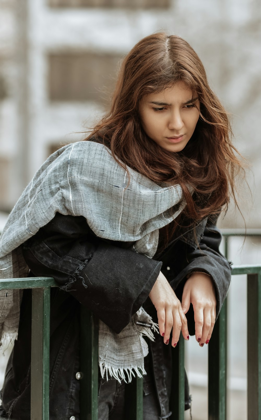 Donna in camicia a maniche lunghe a quadri blu e bianca seduta sulla panca di legno verde