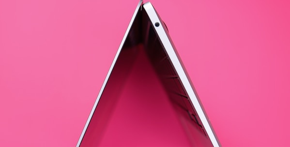 A minimalist digital illustration of a laptop displaying a modern website layout with soft blush pink and warm peach accents.