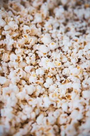A close-up of popcorn coated in caramel with crunchy almonds, capturing the sweet and nutty texture.
