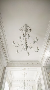 Elegant living room ceiling with intricate staff molding and soft lighting.