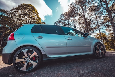 Front view of a silver hatchback car parked outdoors on a sunny day